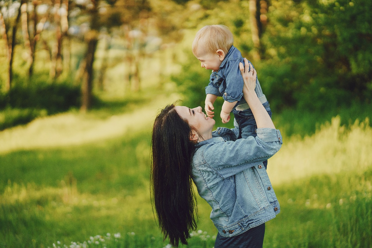 Parent lifting a child outdoors
